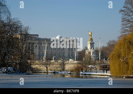 Vue depuis St James Park sur le lac et le palais de Buckingham et le Queen Victoria Memorial en hiver la neige. Banque D'Images