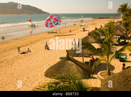 Mexique Mazatlan Sinaloa State Beach avec des parapentes voiliers palapas et les personnes bénéficiant de la vue sur l'océan. Zone d'or Banque D'Images