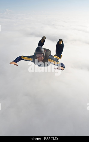 Parachutiste est ventre, sur une base d'un nuage et est plongée dans le bleu. Relations sérieuses in extrême pendant la chute libre dans le ciel avec le soleil Banque D'Images