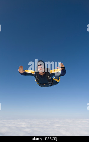 Parachutiste est ventre, sur une base d'un nuage et est plongée dans le bleu. Relations sérieuses in extrême pendant la chute libre dans le ciel avec le soleil Banque D'Images