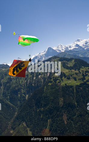 Parachutiste sous voilure va atterrir avec un grand drapeau Berne derrière lui.Avec cette démo jump le plongeur est représente le sport. Banque D'Images