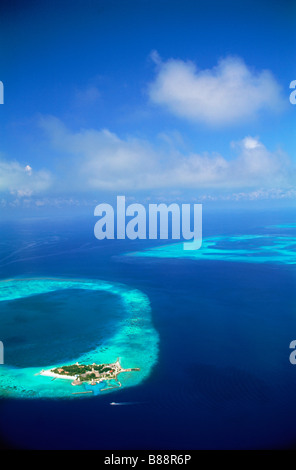 Vue aérienne de l'île de villégiature entouré de récif et aqua bleu océan Indien dans les îles Maldives Banque D'Images