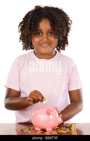 Adorable petite fille africaine de mettre une pièce dans un piggbank sur un fond blanc Banque D'Images
