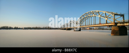 En arc en acier pont ferroviaire sur la rivière gelée Daugava, Riga, Lettonie Banque D'Images