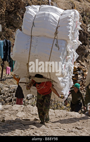 Porter népalais transportant des sacs d'extrême des bouteilles en plastique vides dans Namche Bazar village Népal Banque D'Images