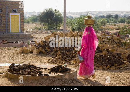 Femme indienne porte pot d'eau sur la tête Khuri desert Rajasthan Inde Banque D'Images