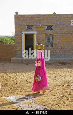 Femme indienne porte pot d'eau sur la tête Khuri desert Rajasthan Inde Banque D'Images