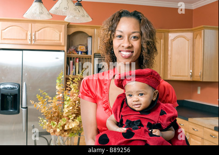 African American Woman pose avec sa petite fille dans la cuisine moderne entièrement rénové Banque D'Images