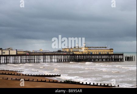 Côte sud de Sussex, une marée montante sur une plage de galets avec Hastings pier en arrière-plan sur une journée l'hiver. Banque D'Images