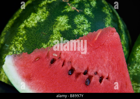 Watermelon slice contre l'extérieur de melon. Banque D'Images