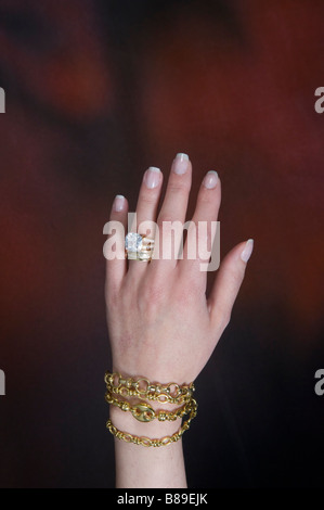 La main de femme portant des gros anneau de diamant et d'or bracelets Banque D'Images