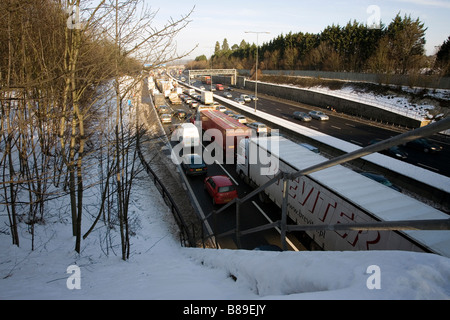 Camions voitures autoroute M25 hiver neige embouteillage Banque D'Images