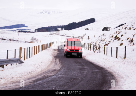 Livraison de Royal Mail à des endroits ruraux éloignés à Glen Clova, Angus, Écosse, sur une route de campagne enneigée. Banque D'Images