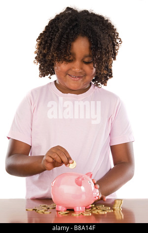 Adorable petite fille africaine de mettre une pièce dans un piggbank sur un fond blanc Banque D'Images