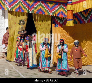 Accompagnement musiciens Danseurs au festival de Mongar, Mongar Tsechu. Les musiciens sont vêtus de robes de soie aux couleurs vives Banque D'Images