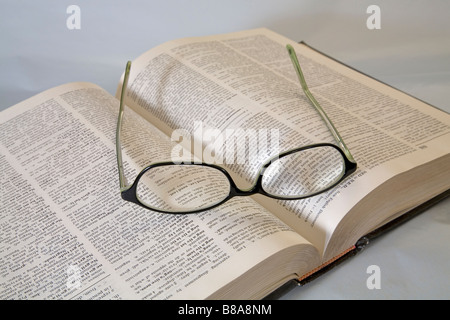 Une paire de lunettes de lecture commune ou spectacles allongé sur un dictionnaire ouvert Banque D'Images