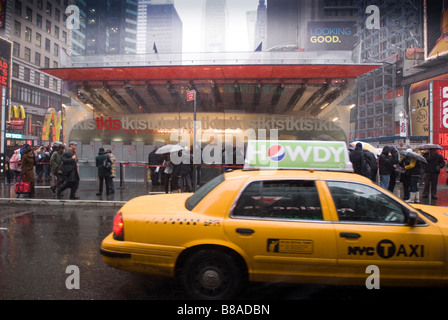 Les spectateurs attendent en ligne dans la neige pour acheter des billets de théâtre à la billetterie TKTS à Times Square Banque D'Images