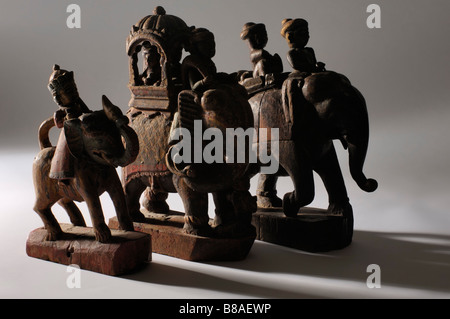 Un groupe d'Indiens anciens bois sculpté peint caparisoned elephants avec cavaliers. Banque D'Images