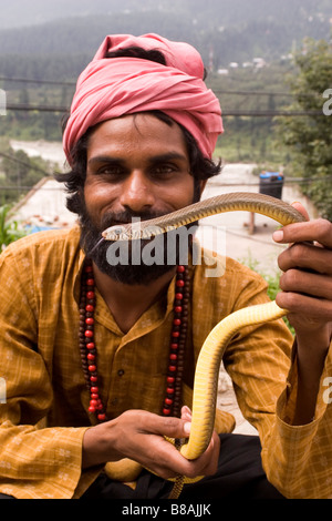 Un snakecharmer tient un serpent dans le règlement de Vashisht près de Manali en Inde du nord. Banque D'Images