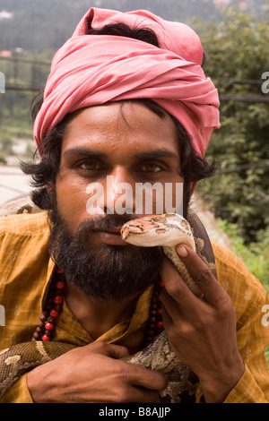 Un snakecharmer tient un serpent dans le règlement de Vashisht près de Manali en Inde du nord. Banque D'Images