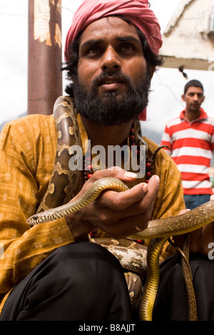 Un snakecharmer tient un serpent dans le règlement de Vashisht près de Manali en Inde du nord. Banque D'Images