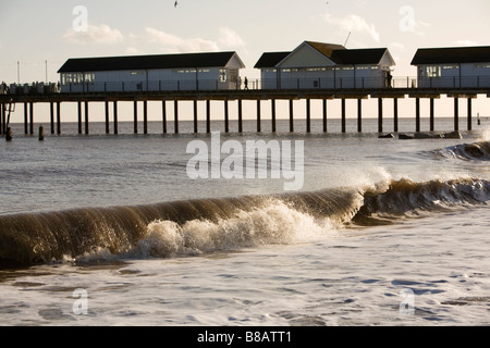 Les vagues déferlent balayées par le casser sur la plage de Southwold pier sur près de la lumière de l'après-midi d'hiver sur le littoral de la côte de Suffolk Banque D'Images