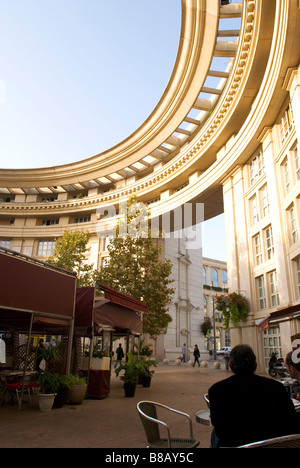 Un homme est assis sur la terrasse d'un café dans le quartier post-moderne Antigone, au centre-ville de montpellier, en france Banque D'Images