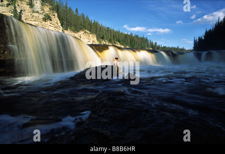 Femme assise Rocks Deh Samba Falls le long de Trout River, 110 kms à l'Est du t Simpson, dans les Territoires du Nord-Ouest Banque D'Images