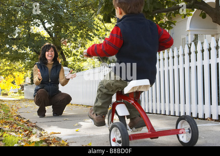 Son Riding Tricycle vers Mère Automne, Brampton, Ontario Banque D'Images