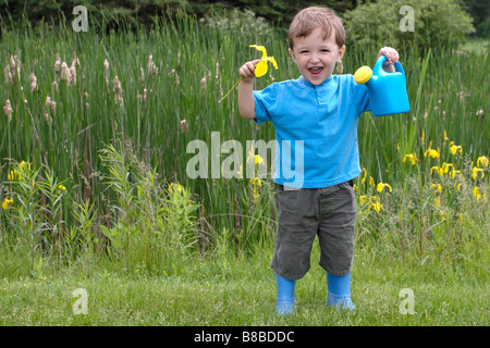 Little Boy Holding Watering Can Flower Banque D'Images