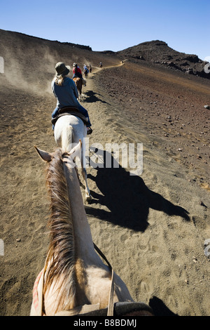 Ligne de chevaux et cavaliers à la tête d'un sentier dans le Parc National de Haleakala cratère de Haleakala Maui Hawaii USA Banque D'Images