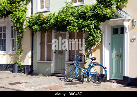 Un vélo bleu appuyé contre une maison dans la région de Sandwich Kent Banque D'Images