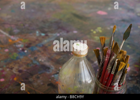 Les Pinceaux de l'artiste et de bouteilles par palette Banque D'Images