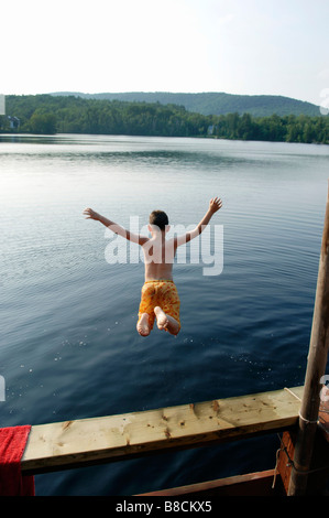 Jeune garçon sautant dans le lac, Lac de neige, Québec Banque D'Images