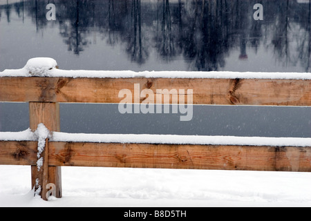 Clôture en bois sur la rivière d'hiver gelé pas banque. Banque D'Images