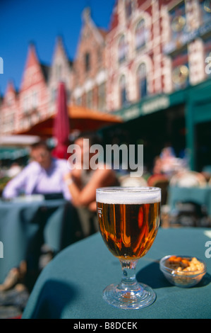 La bière belge sur une table à l'extérieur d'un bar dans le Markt, Bruges, Belgique Banque D'Images