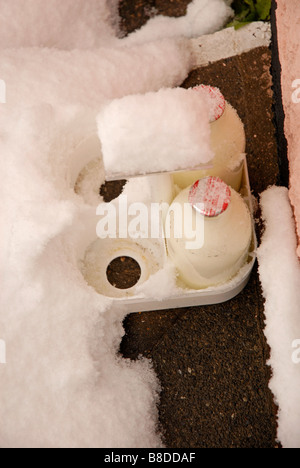 Deux pintes de lait dans des bouteilles en verre livré à la porte dans la neige Banque D'Images