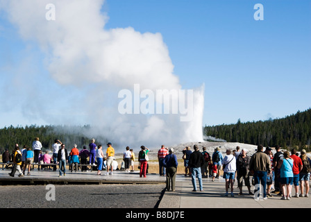 Les touristes à regarder comme Old Faithful Geyser éclate dans le Parc National de Yellowstone Banque D'Images