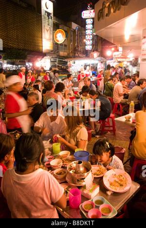 Les gens de manger au restaurant du coin de la rue animée - Thanon Yaowarat road dans le quartier chinois centre de Bangkok Thaïlande Banque D'Images