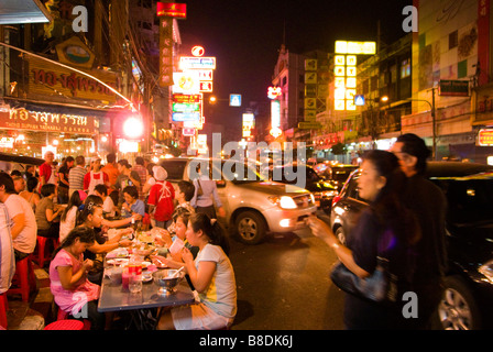 Les gens de manger au restaurant du coin occupé près de fort trafic - Thanon Yaowarat road dans le quartier chinois centre de Bangkok Thaïlande Banque D'Images