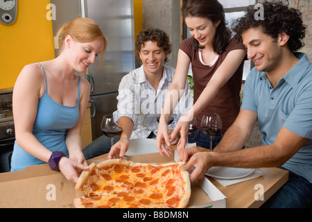Les amis partageant une pizza Banque D'Images