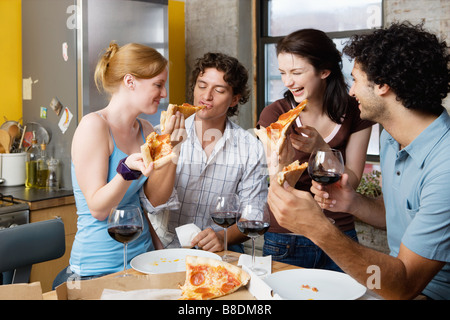 Partage d'une pizza à la maison d'amis Banque D'Images