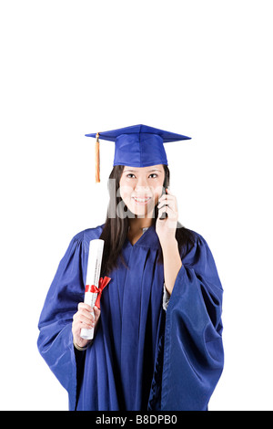 Jeune fille diplômé on cellphone Banque D'Images