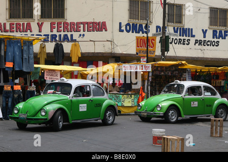 Deux taxis vert et blanc de coléoptère conduisant à travers un marché à Mexico, Mexique, Amérique du Sud Banque D'Images