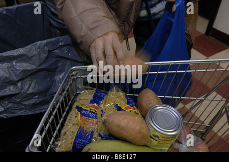 Un des sacs d'épicerie à son client la banque alimentaire de NYC Food Pantry dans le quartier de Harlem, New York Banque D'Images