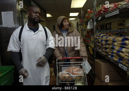 Un client boutiques pour l'épicerie avec un travailleur de la banque alimentaire de NYC Food Pantry dans le quartier de Harlem, New York Banque D'Images