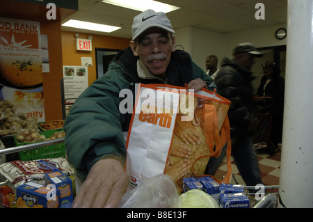 Un des sacs d'épicerie à son client la banque alimentaire de NYC Food Pantry dans le quartier de Harlem, New York Banque D'Images