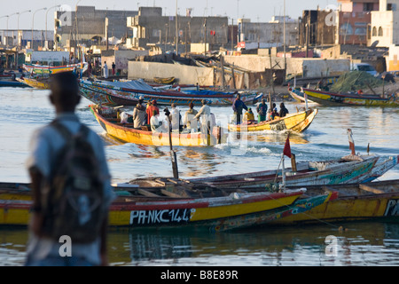 Montres d'écolier comme bateaux de pêche passent à St Louis au Sénégal Afrique de l'Ouest Banque D'Images