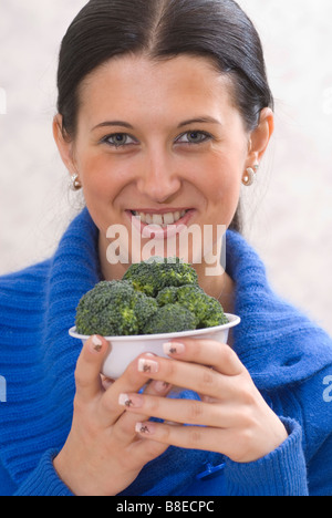 Femme tenant un bol de légumes brocoli Banque D'Images