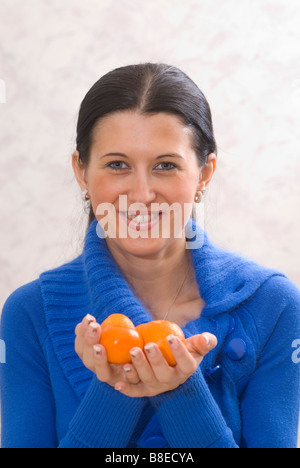 Belle Jeune femme tenant un fruit mandarin Banque D'Images